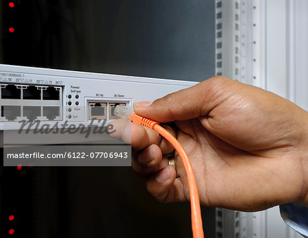 Businessman plugging cord into server