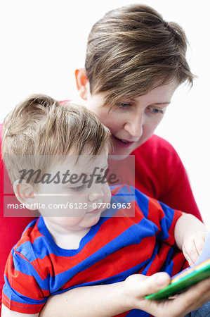 Mother and son reading book together