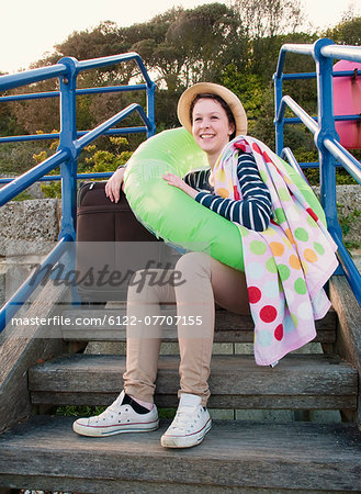 Teenage girl with suitcase on steps