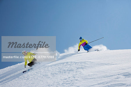 Skiers coasting on snowy slope