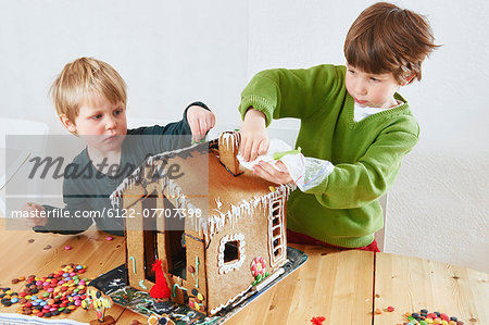 Boys decorating gingerbread house
