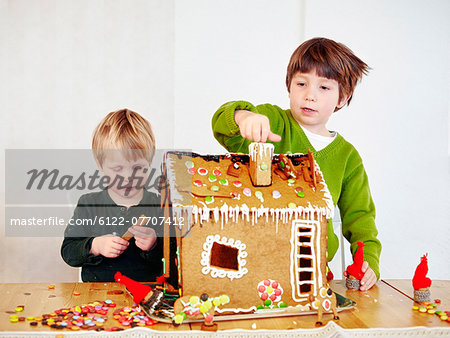 Boys decorating gingerbread house