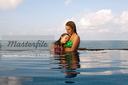 Mother and daughter in infinity pool