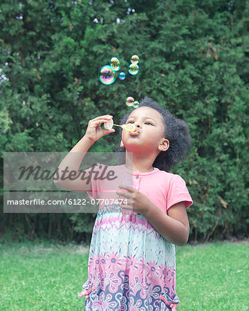 Girl blowing bubbles outdoors