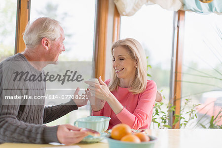 Mature couple chatting about text message on smartphone