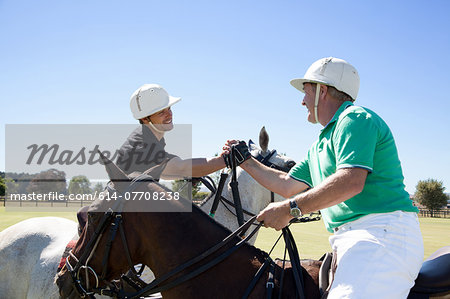 Two polo players shaking hands