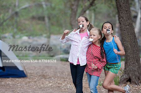 Portrait of three children eating toasted marshmallows whilst camping, Sedona, Arizona, USA