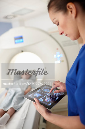 Radiographer looking at brain scan image on digital tablet Radiographer looking at brain scan image on digital tablet