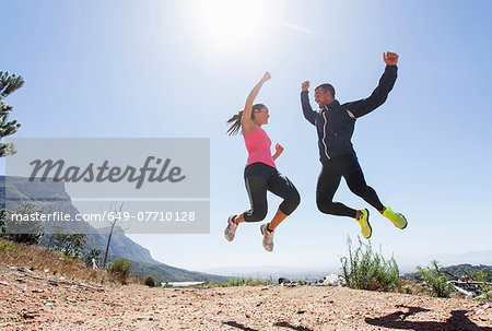 Young joggers jumping in mid air