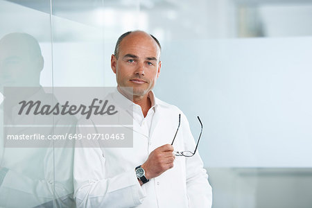 Male doctor leaning against reflective wall