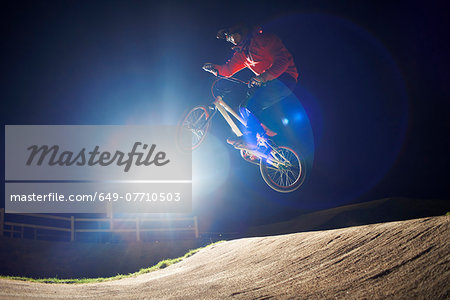 BMX-cyclist jumps his bike at night time