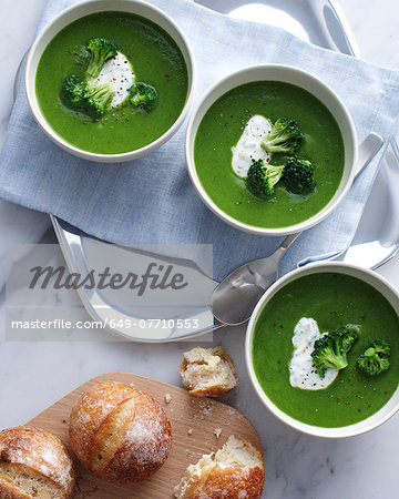 Still life of bowls of broccoli soup with sour cream