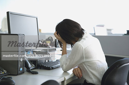 Japanese young businesswoman depressed at her office desk