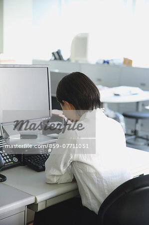 Japanese young businesswoman depressed at her office desk