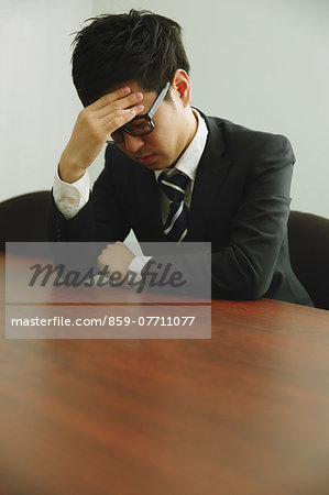 Desperate Japanese young businessman in a suit