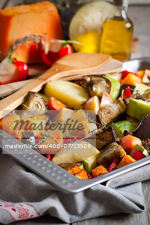 Mixed roasted vegetables with thyme in a tray. Selective focus.