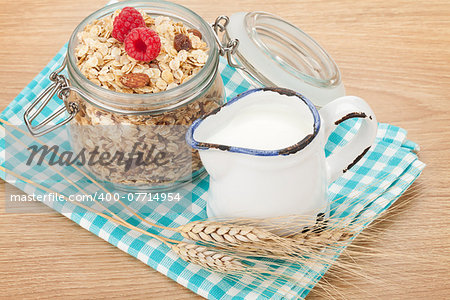 Healty breakfast with muesli, berries and milk. On wooden table