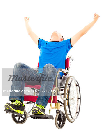 excited young man sitting on a wheelchair and raising hands