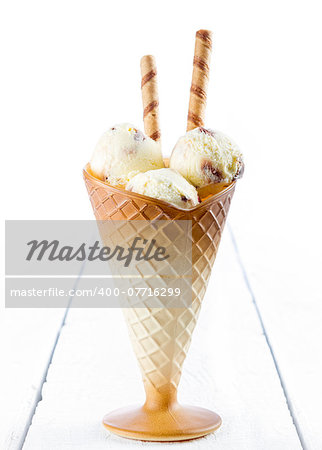 Vanilla ice cream  with wafer in cup on white wooden background