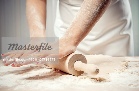 Woman rolling dough, close-up photo