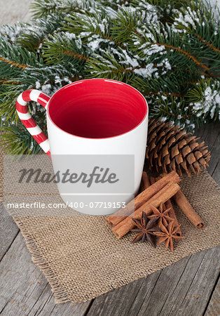 Empty cup for mulled wine, spices and fir tree on wooden table