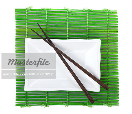 Chopsticks and utensils over bamboo mat. Isolated on white background