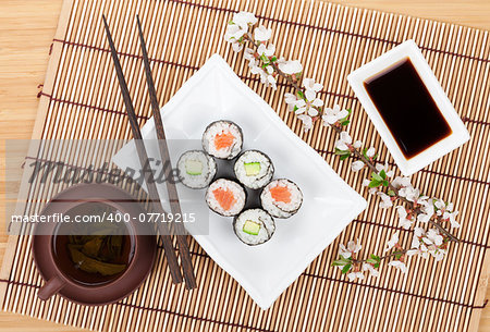 Sushi maki set with salmon and cucumber and green tea. Isolated on white background