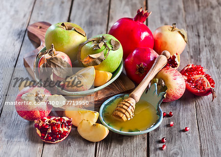 Pomegranate, apple and honey, traditional food of jewish New Year celebration, Rosh Hashana. Selective focus.