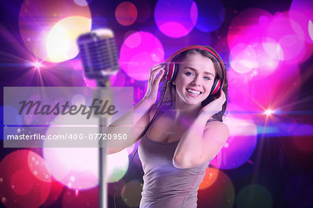 Pretty girl listening to music against digitally generated cool nightlife design