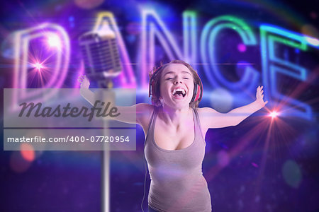 Pretty girl listening to music against digitally generated colourful dance text