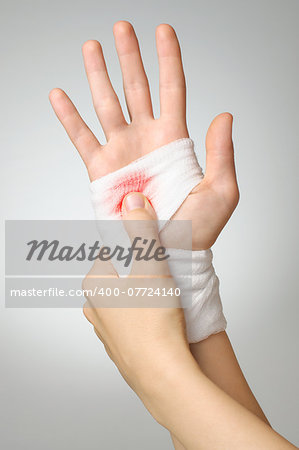 Injured hand with bloody white gauze bandage