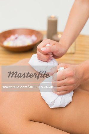 Woman enjoying a herbal compress massage in the health spa