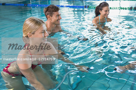 Fitness class doing aqua aerobics on exercise bikes in swimming pool at the leisure centre