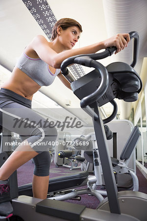 Fit woman working out on the exercise bike at the gym