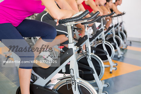 Spin class working out in a row at the gym