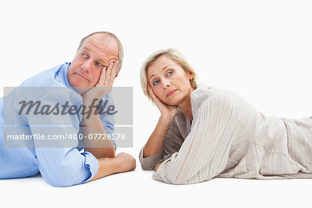 Mature couple lying and thinking on white background