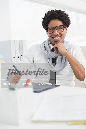 Hipster businessman working at his desk in his office