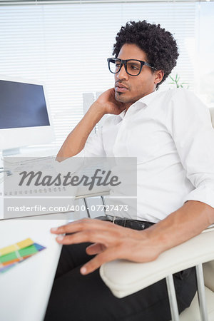 Hipster businessman working at his desk in his office
