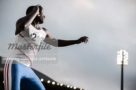 Track and field athlete throwing shot put