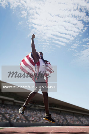 American track and field athlete cheering on track with American flag