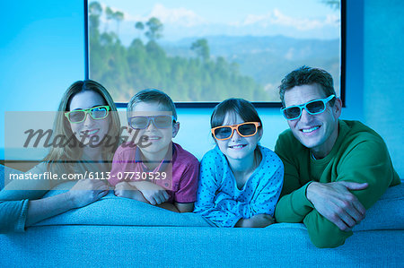 Family wearing 3D glasses in living room