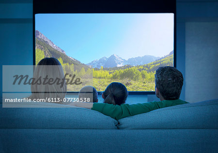 Family watching television in living room