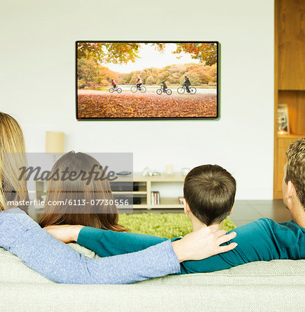 Family watching television in living room