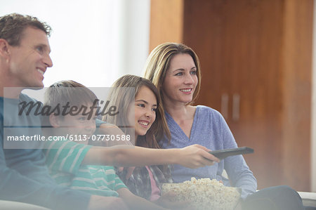 Family watching television in living room