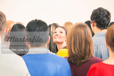 Confident woman looking up in crowd