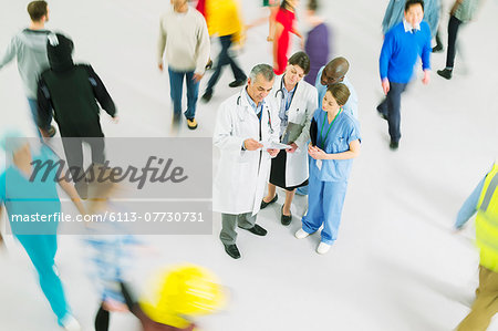 Bustling crowd around doctors and nurses