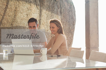 Couple using laptop at breakfast