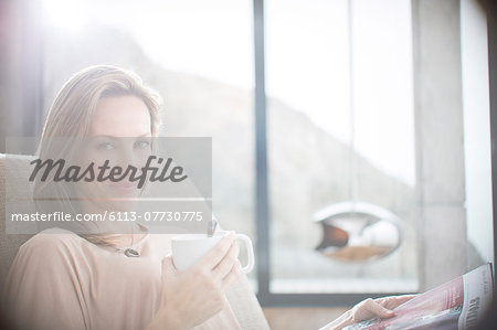 Woman having cup of coffee on sofa