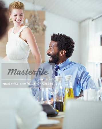 Man laughing at dinner party