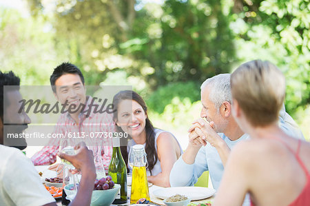 Friends talking at table outdoors